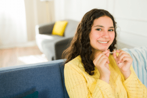 Teen patient holding Invisalign aligners while learning about attachments in Gorham, ME