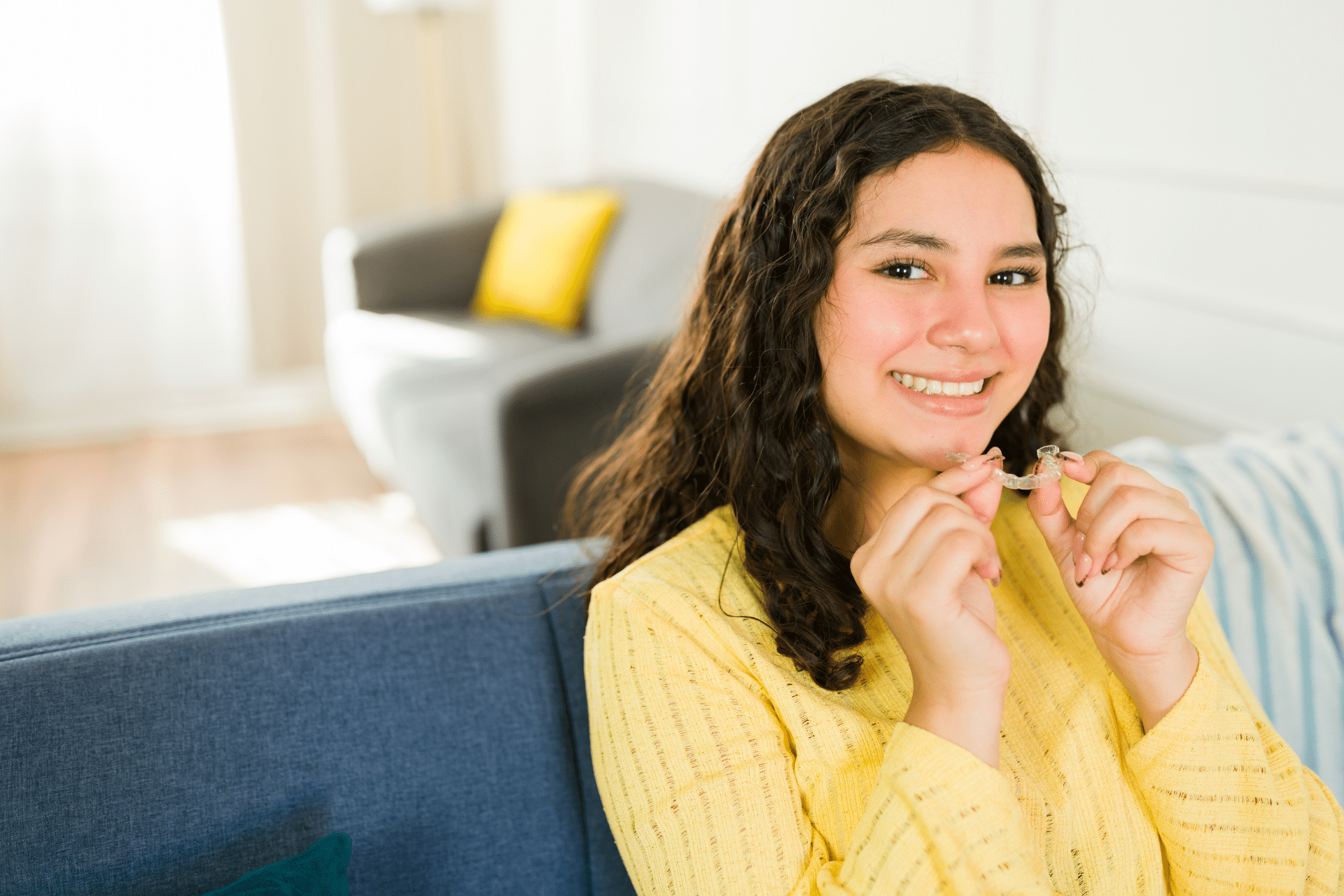 Teen patient holding Invisalign aligners while learning about attachments in Gorham, ME